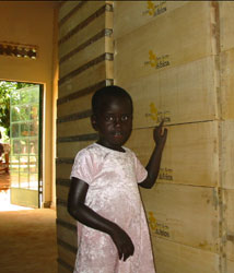 Young girl standing next to hives.